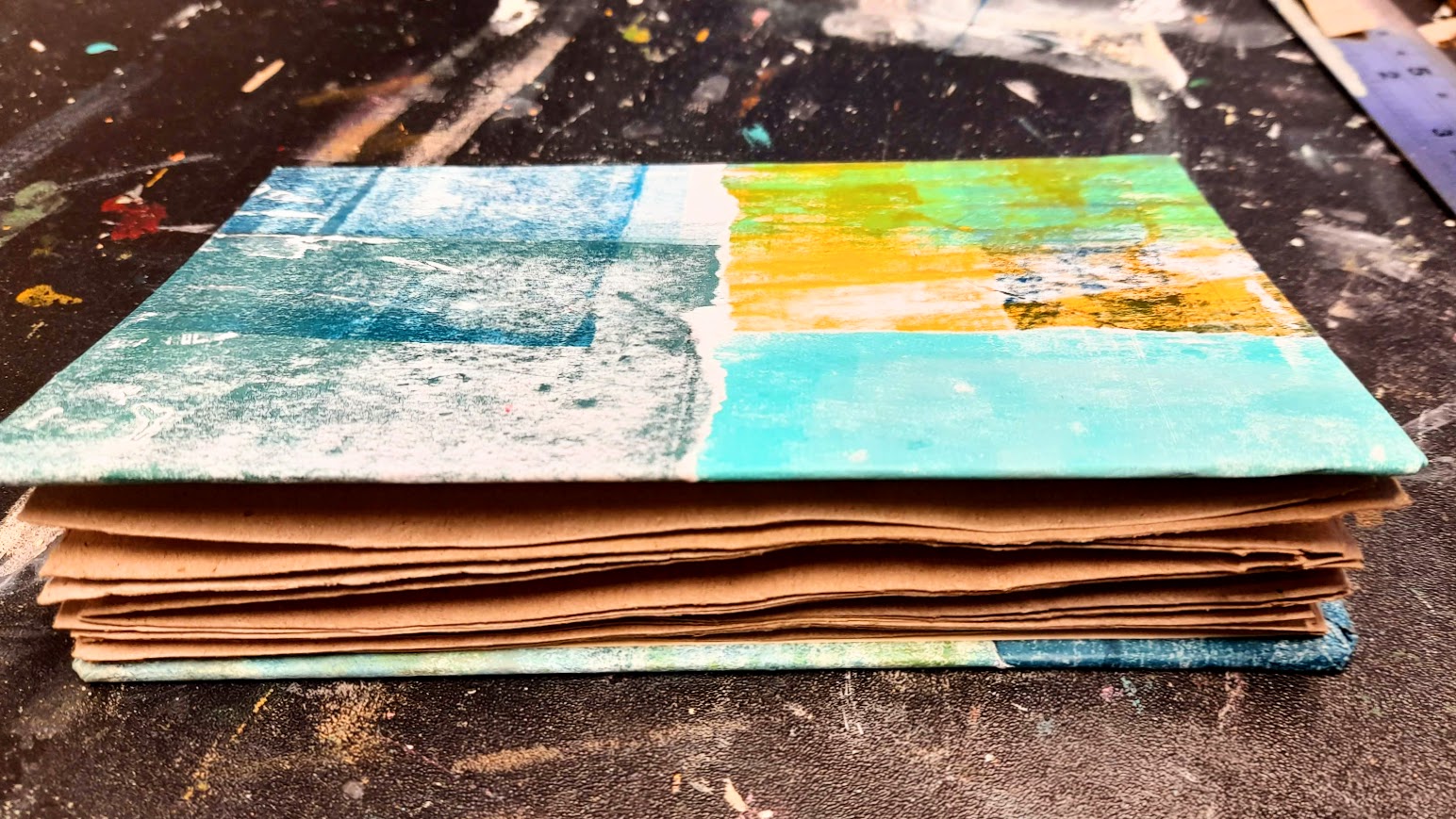 Junk journal tehty kirjankansista ja ruskeasta kierrätyspaperista.
